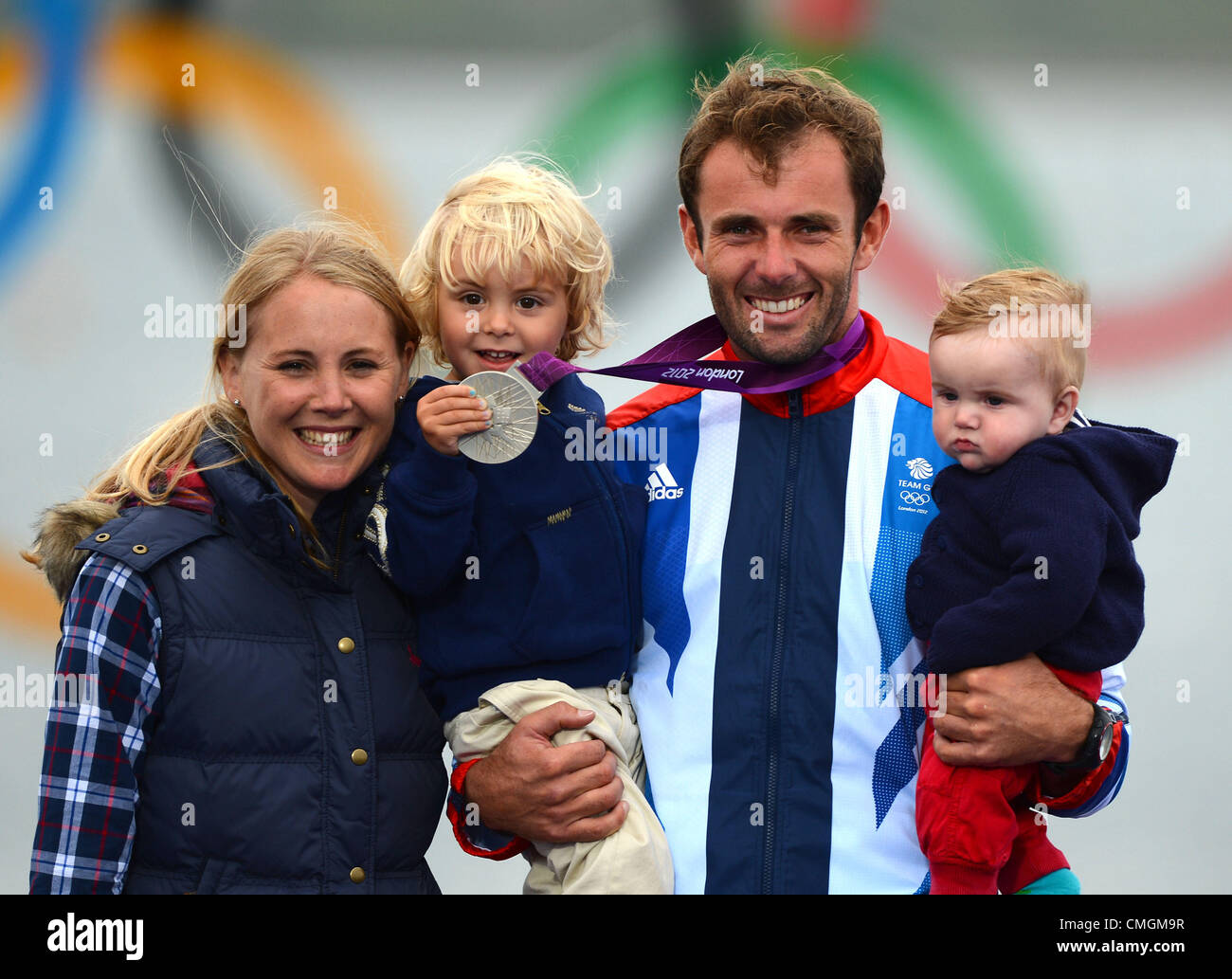 Olympisches Segeln, Aktion während der London 2012 Olympische Spiele bei Weymouth & Portland Veranstaltungsort, Dorset, England, UK.  Nick Dempsey von Großbritannien gewinnt Silber in der RS: x Männer Windsurfen Klasse, im Bild mit seiner Familie, Frau Sarah und Söhne Thomas und Baby Oscar 7. August 2012 Bild: DORSET MEDIA SERVICE Stockfoto