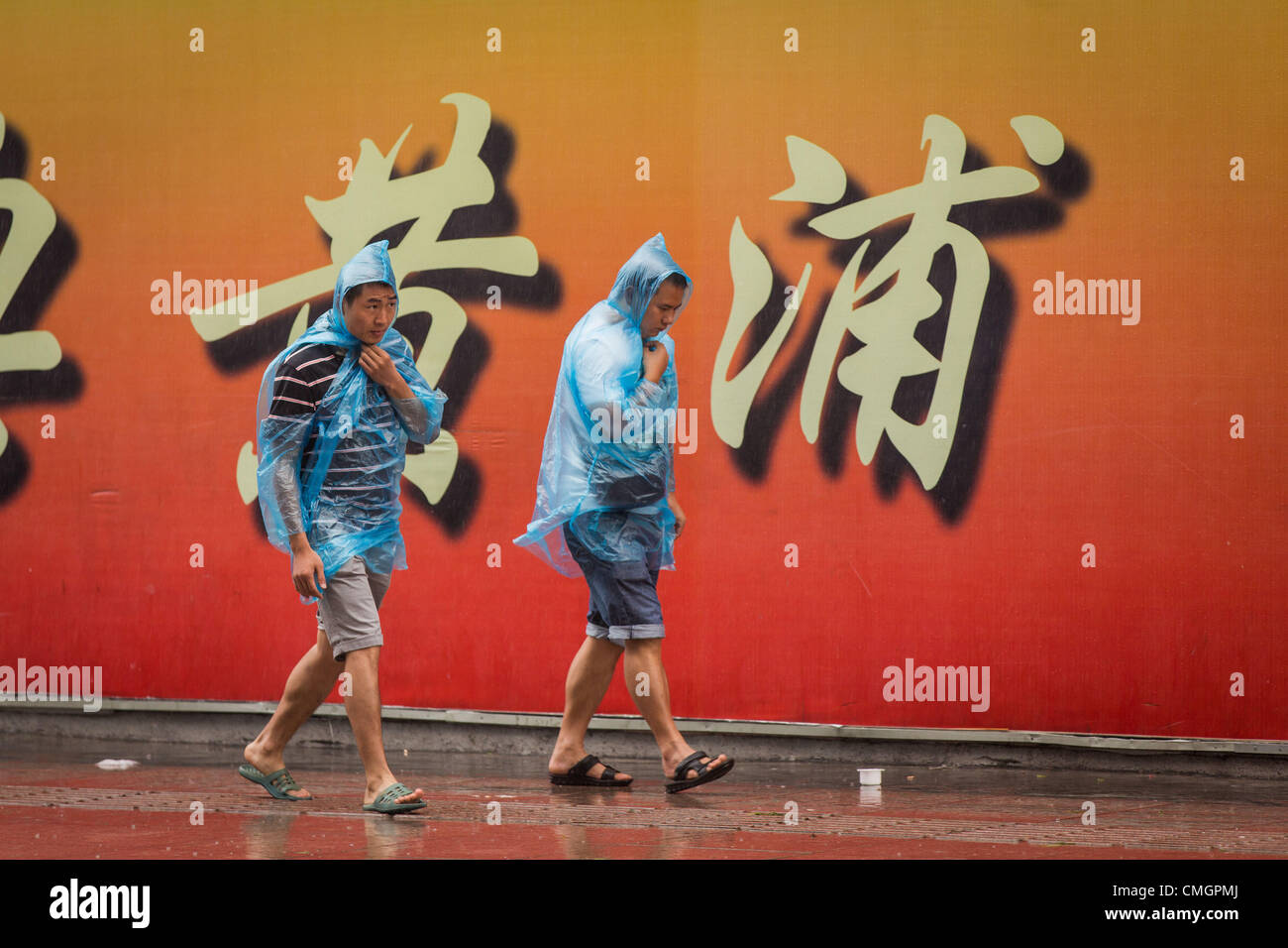 Menschen versuchen trocken zu bleiben, wie Taifun Haikui Landfall in Ostchina bewirken Leben für 23 Millionen Menschen im Geschäftszentrum von Shanghai am 8. August 2012 in Shanghai, China. Stockfoto