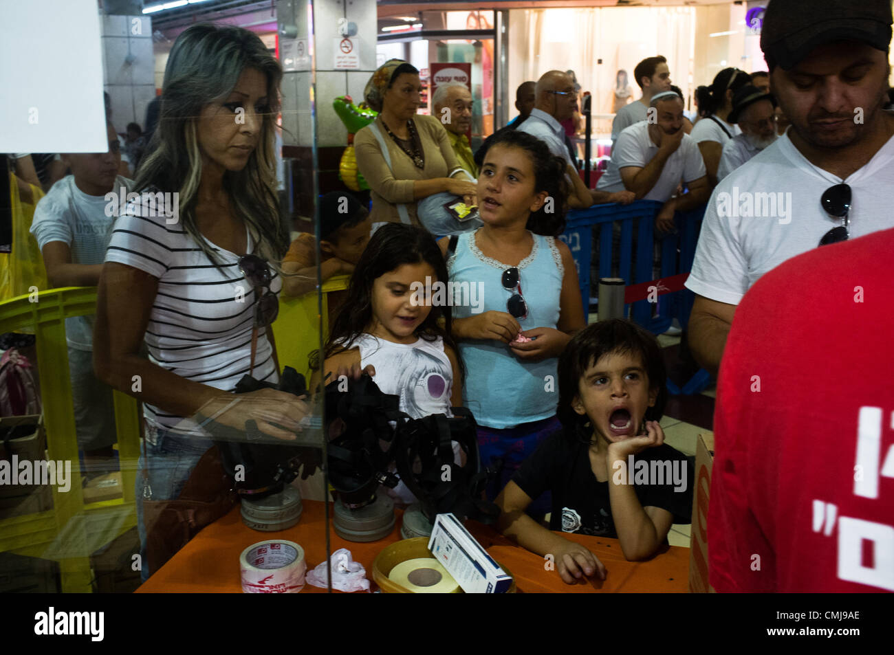 15. August 2012. Ganze Familien kommen an eine Gasmaske Verteilungspunkt in Hadar Shopping Mall. Durchschnittliche Wartezeit beträgt drei Stunden. Jerusalem, Israel. 15. August 2012.  Zivilisten strömen Gasmaske Verteilungspunkt als Erneuerung der veralteten chemischen/biologischen Kriegsführung Verteidigung Kits Heimatfront Befehl fordert. Antwort in Jerusalem steigt mit überwältigender Mehrheit wegen in Jerusalem-Teheran Kriegsrhetorik erhöht. Stockfoto