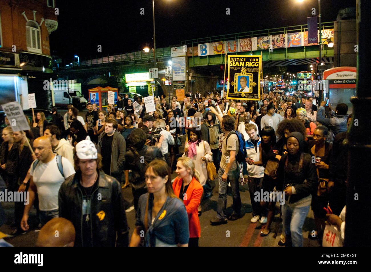 London, UK. 21.08.12. Die Familie von Sean Rigg, während in Polizeigewahrsam gestorben werden von den Mitgliedern der Gemeinschaft, Demonstranten und Kämpfer für Gerechtigkeit verbunden, wie sie marschieren, Brixton Polizeistation eine Minuten Stille zu halten. Stockfoto