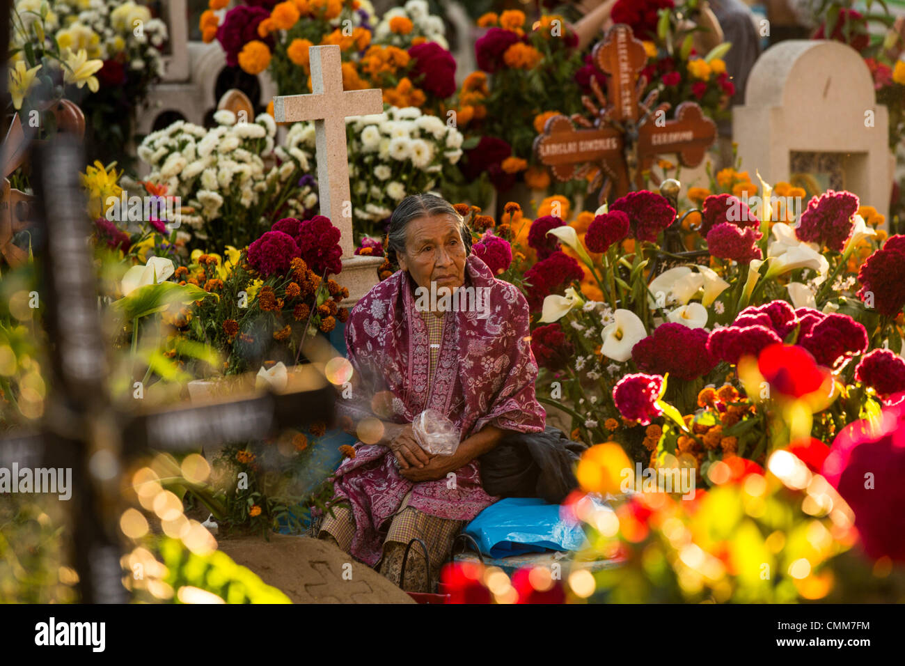 Eine alte mexikanische Frau sitzt am Grab eines geliebten auf dem reich verzierten San Antonillo Castillo Velasco Friedhof im Laufe des Tages von den Dead Festival in Spanisch als D'a de Muertos am 3. November 2013 in Ocotlan, Oaxaca, Mexiko bekannt. Der Friedhof hat einen Wettbewerb für das beste dekorierte Grab. Stockfoto