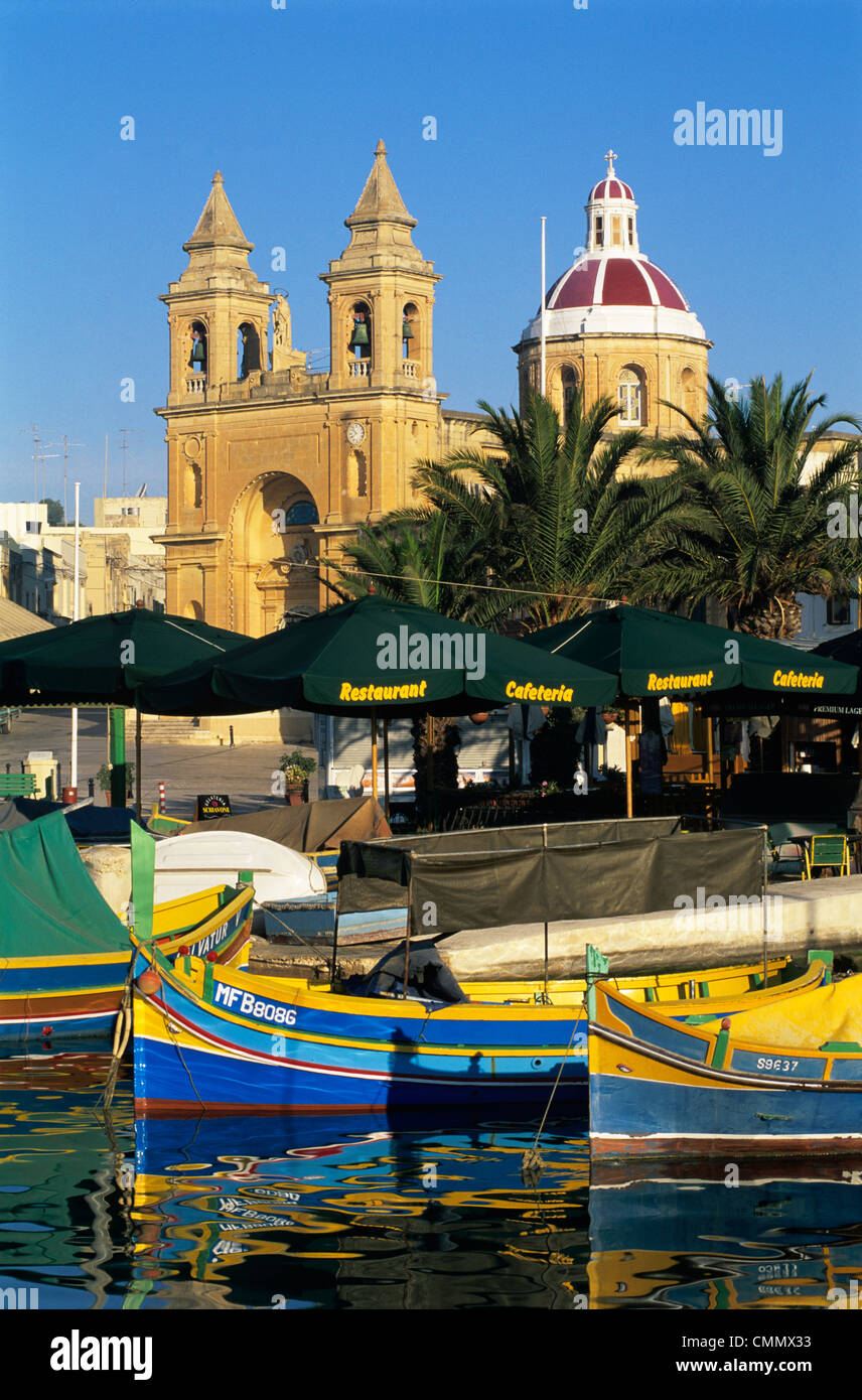 Hafen Sie mit Fischerbooten Luzzu und Marsaxlokk Pfarrkirche, Marsaxlokk, Malta, Mittelmeer, Europa Stockfoto
