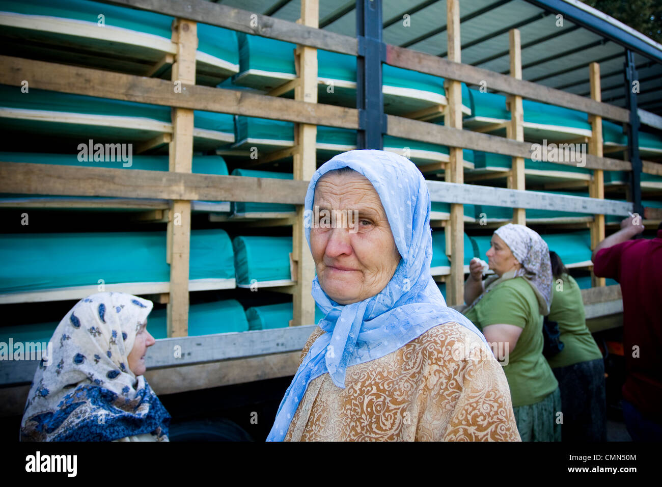 Eine bosnische Muslimin weint als LKW beladen mit Särgen der 307 identifizierte Opfer des Massakers von Srebrenica 1995 von bis zu 8,0 Stockfoto