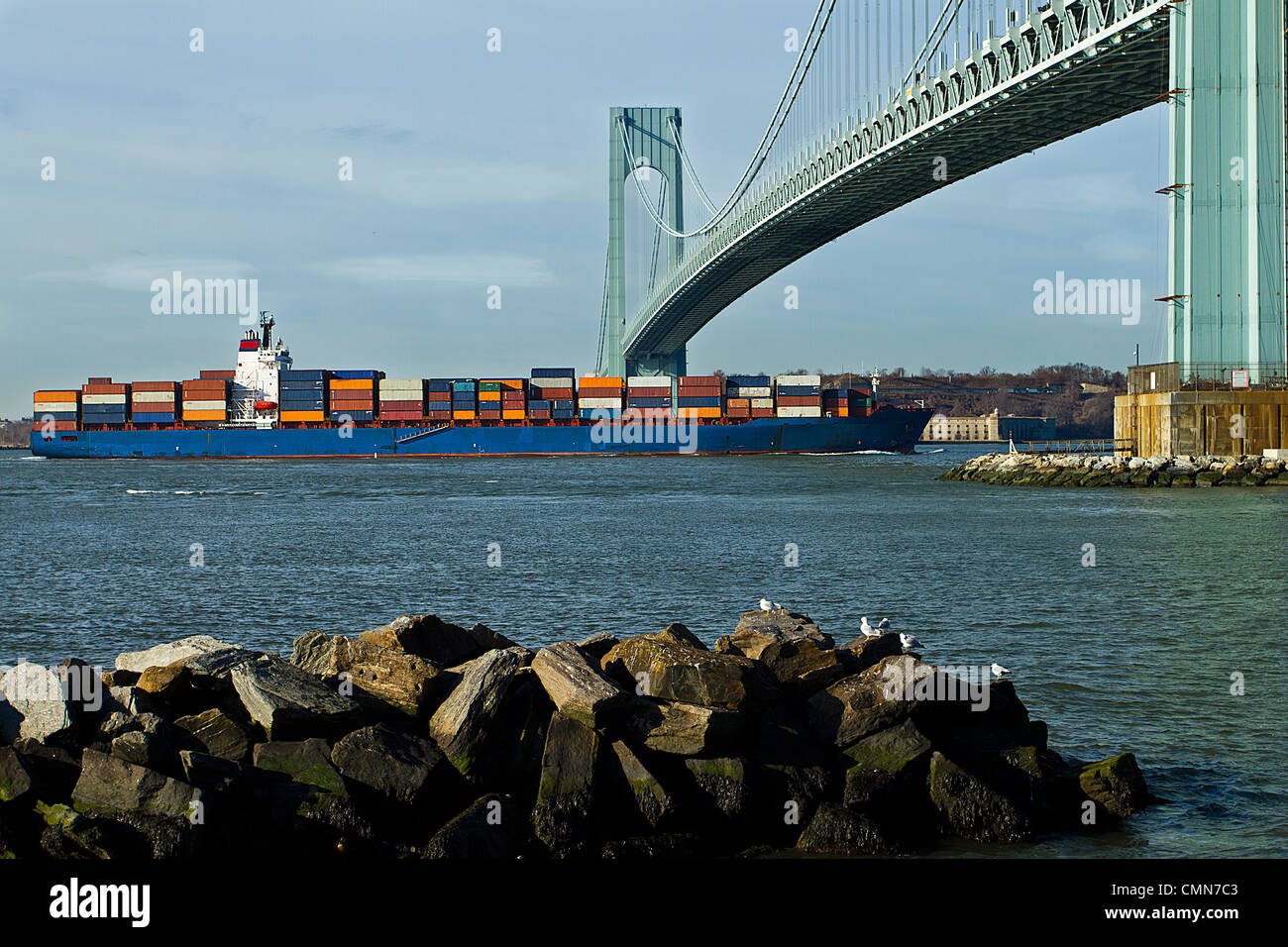 ein Frachtschiff vorbei unter Verrazano Brücke in New York Hafen der Stadt. Stockfoto