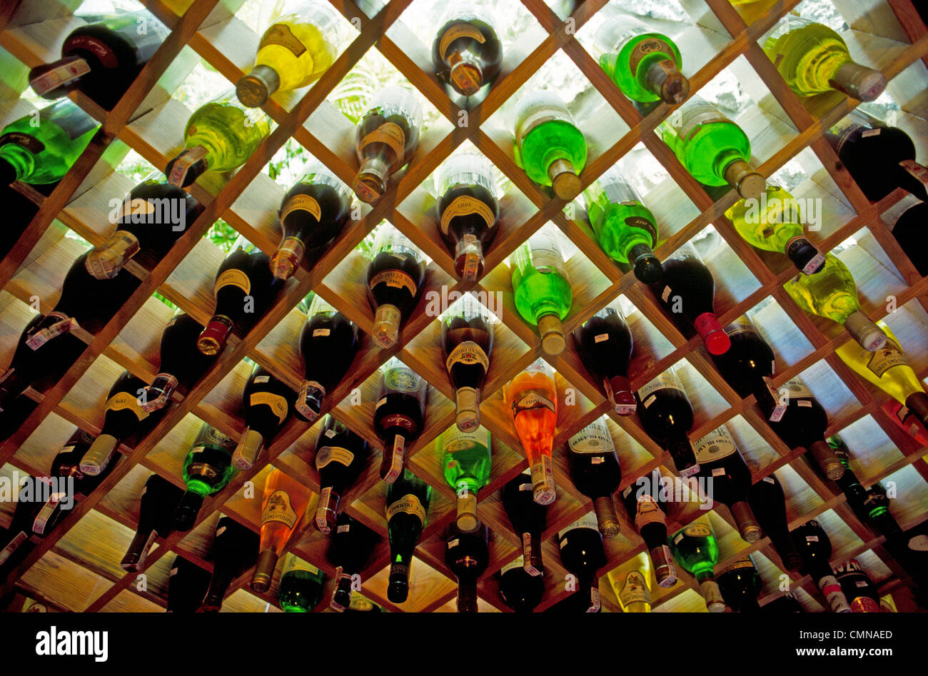 Bunte Flaschen Wein werden in eine hölzerne Weinregal angezeigt, die gegen  eine beleuchtete Wand in einem Restaurant in der Schweiz ist  Stockfotografie - Alamy