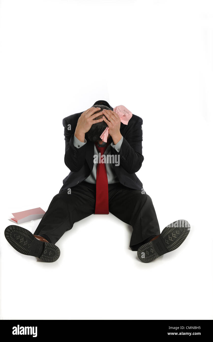 Entlassen Geschäftsmann sitzt deprimiert auf dem Boden isoliert auf weißem Hintergrund Stockfoto