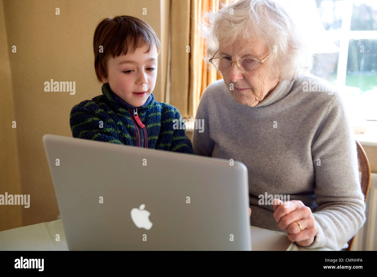 Großeltern und Enkel spielen auf einem Apple Mac Book pro. Stockfoto