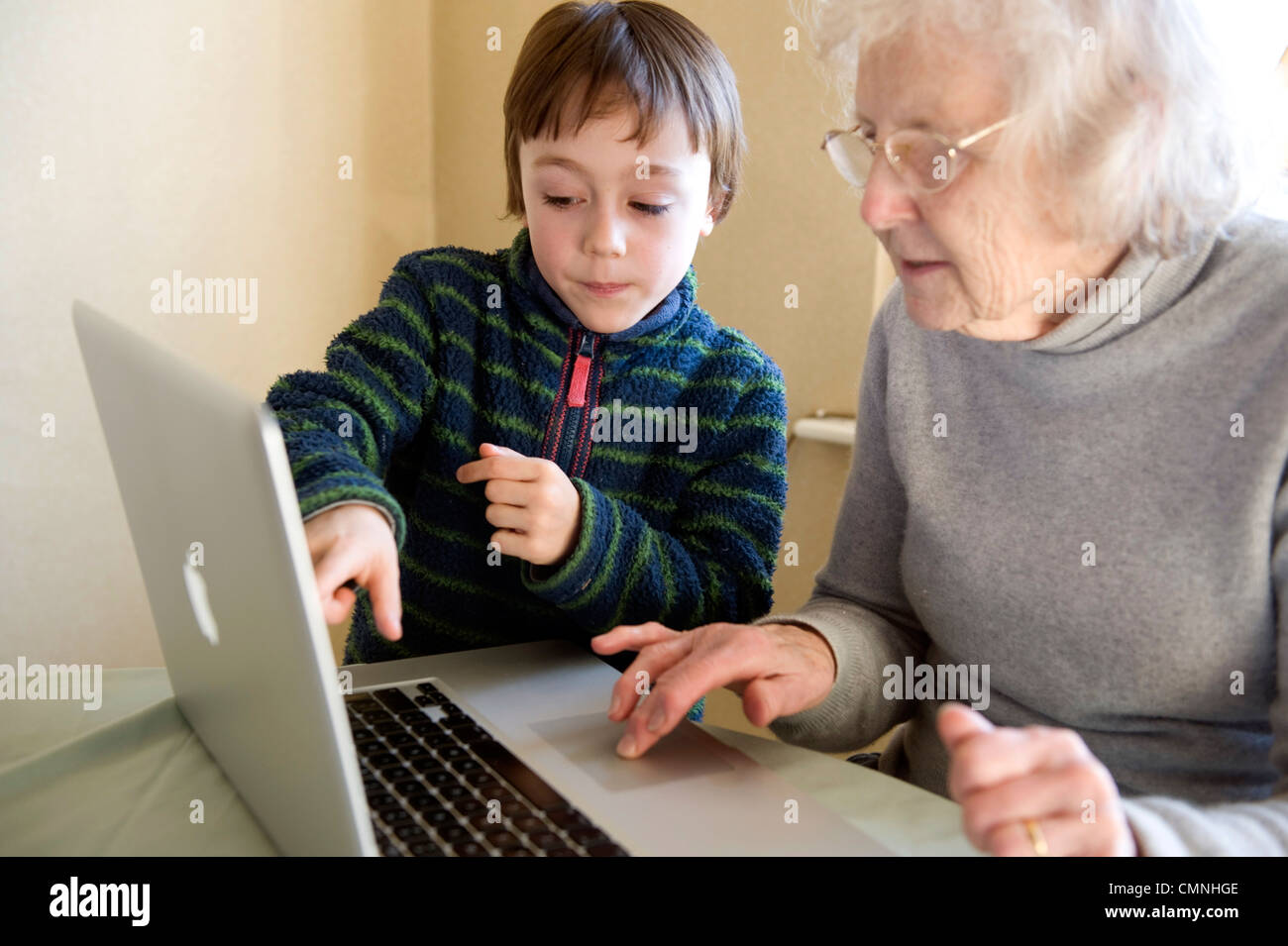 Großeltern und Enkel spielen auf einem Apple Mac Book pro. Stockfoto