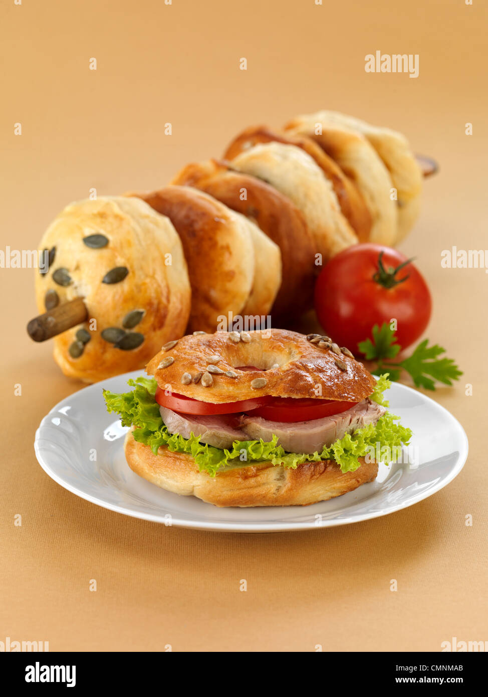 Leckere Bagel mit Salat, Tomate und gehackt. Wir verwendeten leichten braunen Hintergrund. Stockfoto