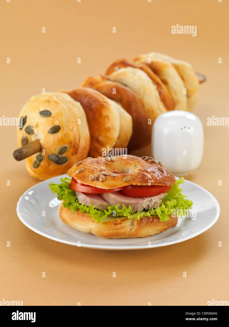 Leckere Bagel mit Salat, Tomate und gehackt. Wir verwendeten leichten braunen Hintergrund. Stockfoto