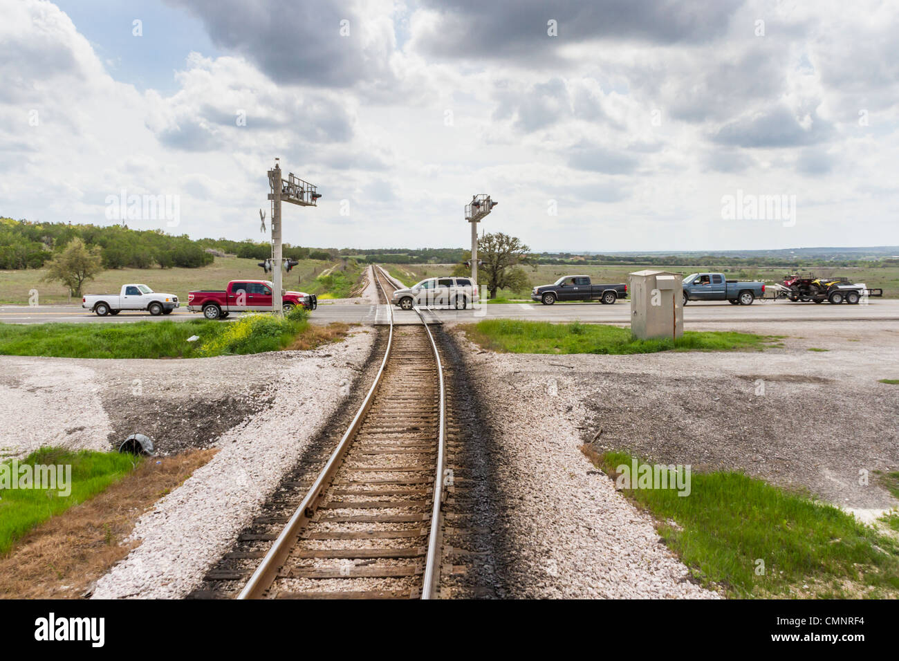 Fahrzeuge überqueren Bahngleise an der Zugkreuzung in Cedar Park (Vorort Austin) im Zentrum von Texas. Stockfoto