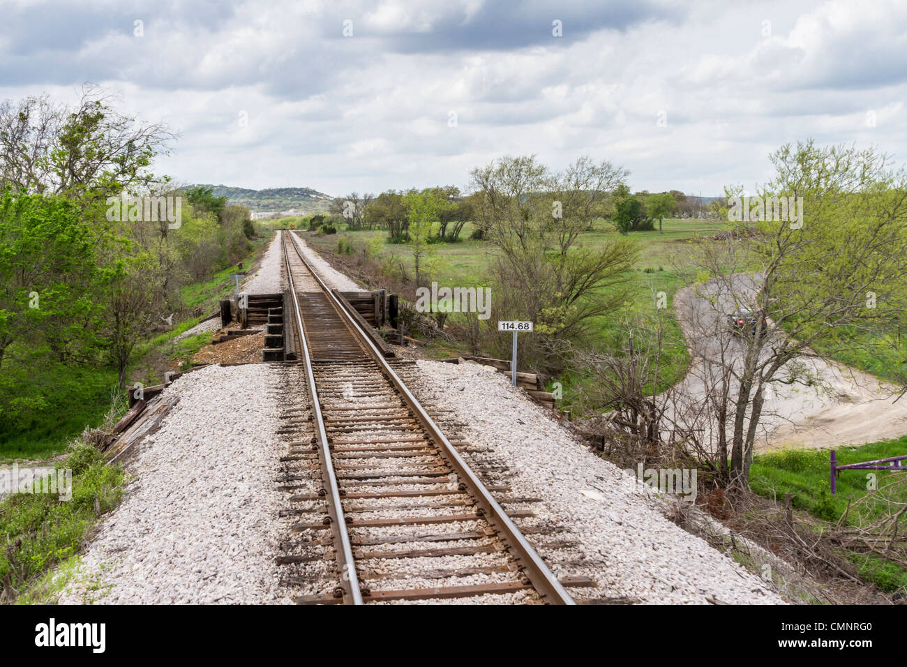 Eisenbahnunterführung mit Bahngleisen oben und Auto unten - Austin und Texas Central Railroad, zwischen Austin und Burnett, Texas. Stockfoto
