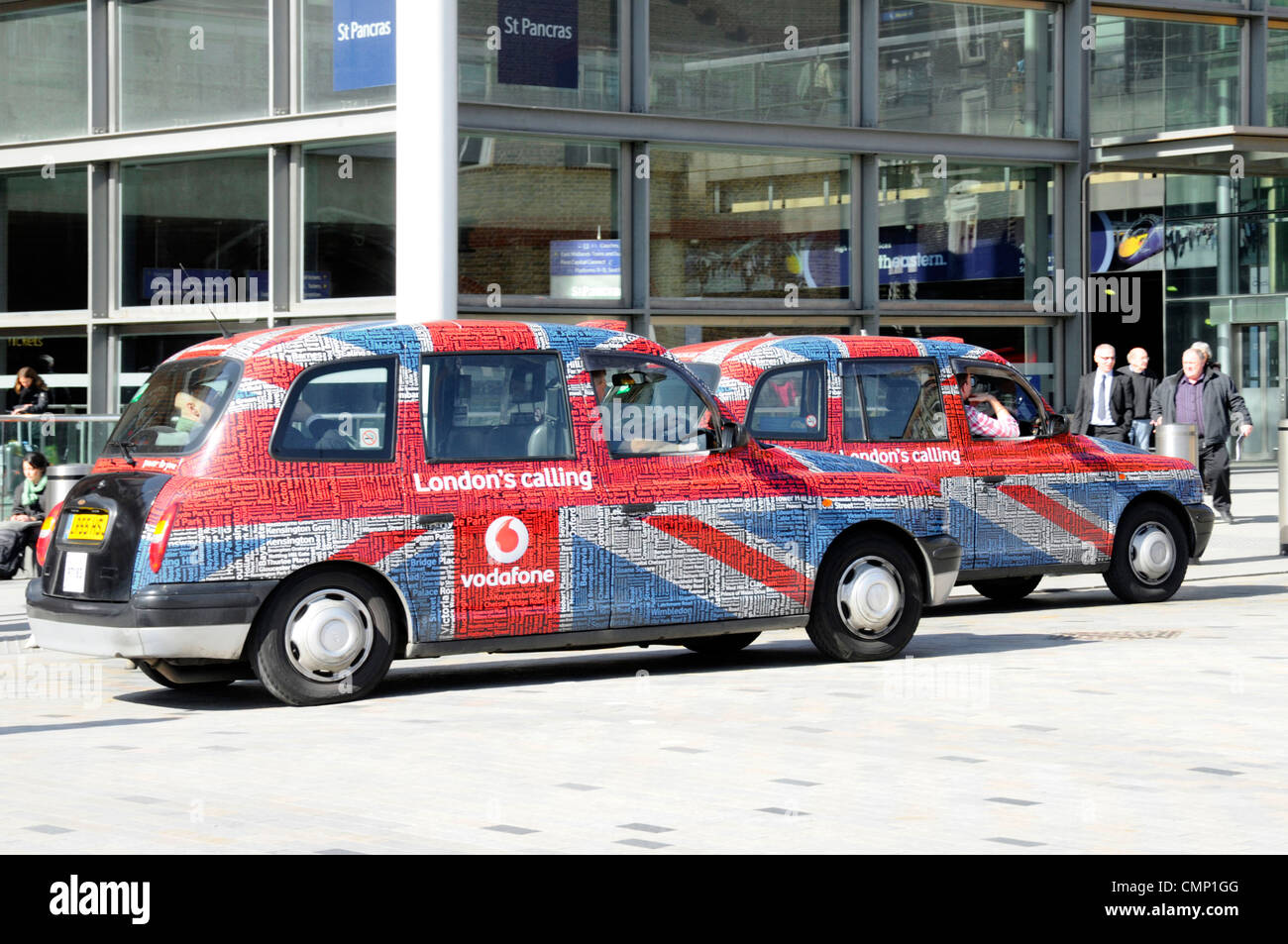 Paar schwarz Taxi Taxi vorübergehend bedeckt ungewöhnliche Vodafone London Calling Union Jack Flagge & Text Tag Wort Wolke Werbung Grafik St Pancras England Großbritannien Stockfoto