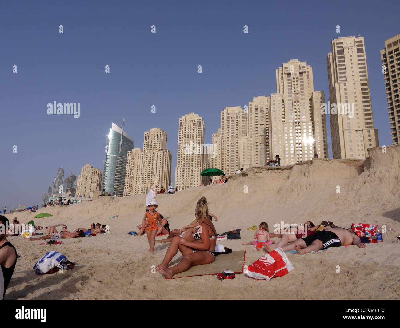 Vereinigte Arabische Emirate – Menschen genießen Jumeirah Beach mit Dubais Wohnwohnungen im Hintergrund, die Entspannung am Meer mit dem Stadtleben verbinden Stockfoto
