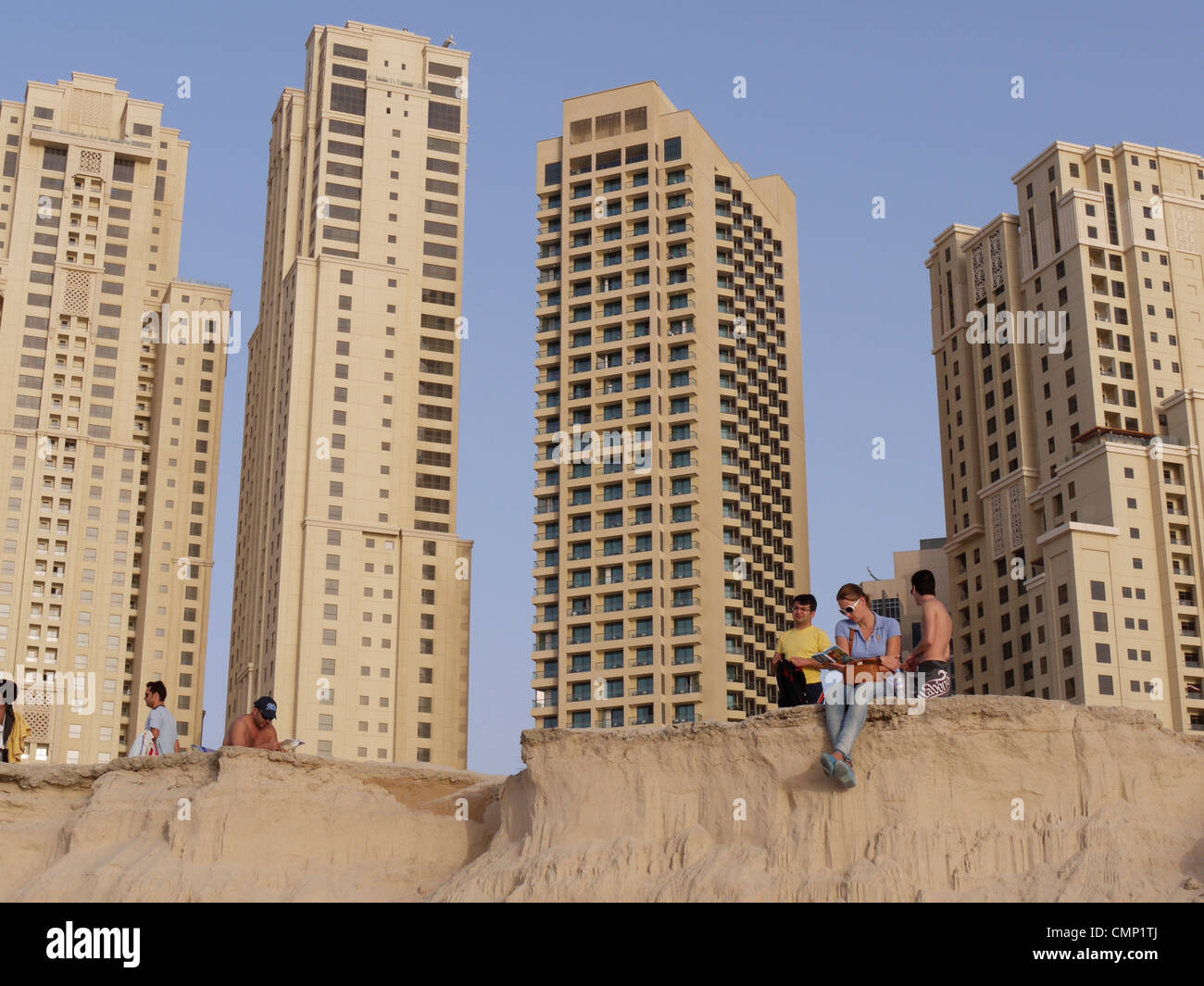 Vereinigte Arabische Emirate – Menschen genießen Jumeirah Beach mit Dubais Wohnwohnungen im Hintergrund, die Entspannung am Meer mit dem Stadtleben verbinden Stockfoto