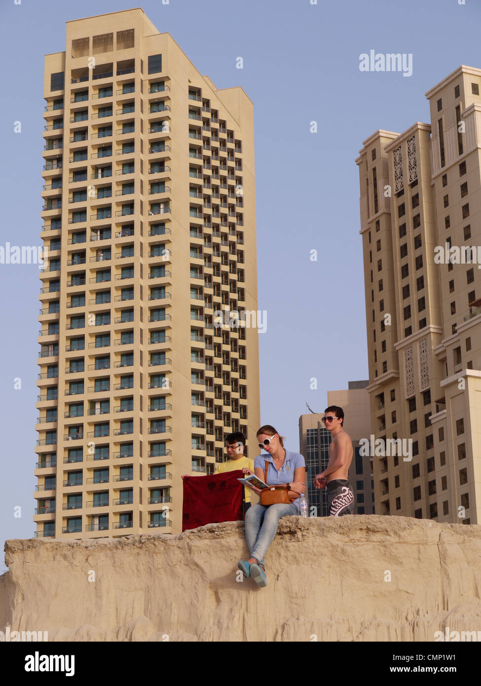 Vereinigte Arabische Emirate – Menschen genießen Jumeirah Beach mit Dubais Wohnwohnungen im Hintergrund, die Entspannung am Meer mit dem Stadtleben verbinden Stockfoto