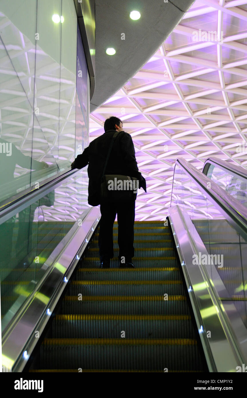 Öffentliche Verkehrsmittel Silhouette der Person indoor auf Rolltreppe am Londoner Bahnhof mit beleuchteten Dach über Kings Cross Bahnhof UK Stockfoto