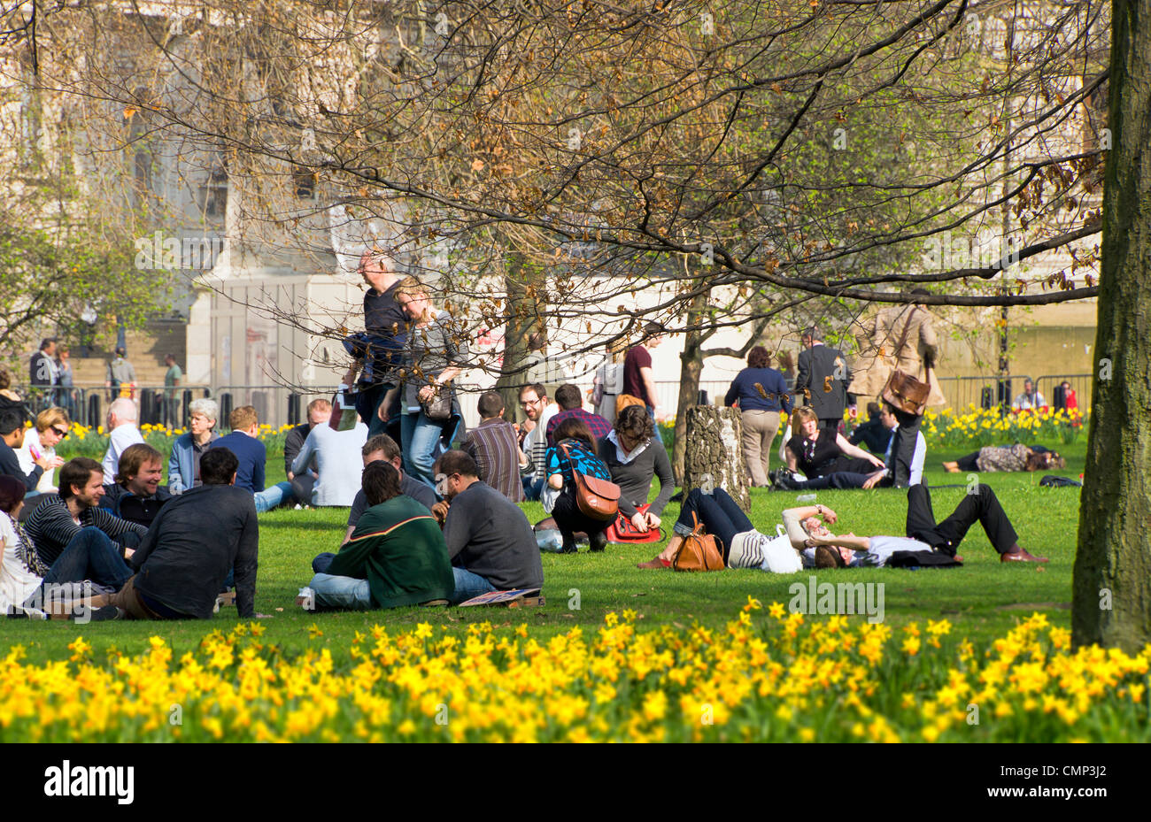 Büroangestellte und Touristen entspannen Sie bei einem Sandwich in St James Park in London Stockfoto
