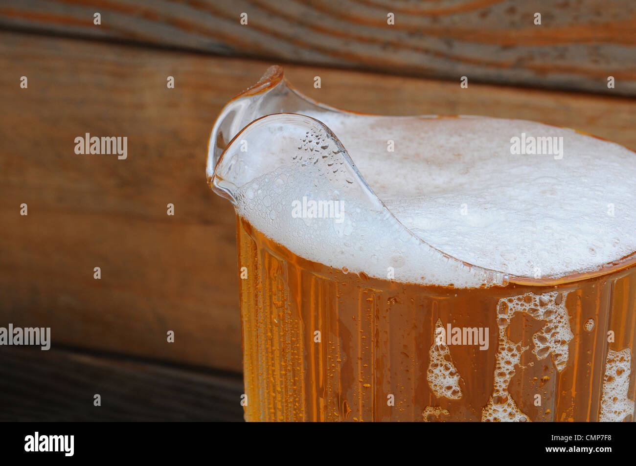 Nahaufnahme der einen vollen Krug Bier vor einem rustikalen Holz Hintergrund. Stockfoto
