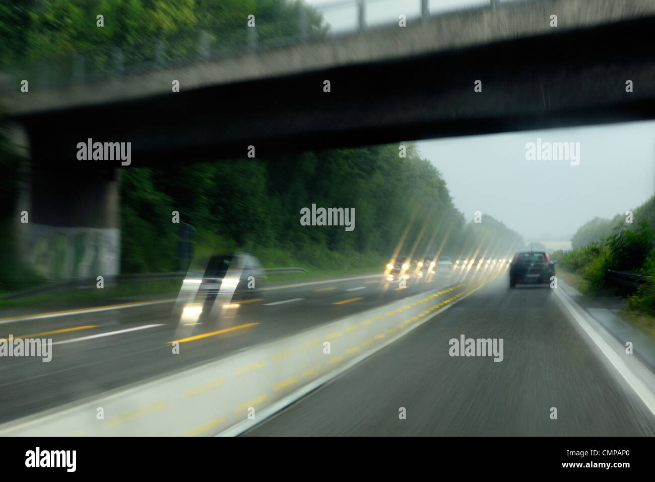 Vorsätzliche Bewegungsunschärfe. Fahren auf deutschen Autobahnen Autobahn in Nordrhein-Westfalen in der Nähe von Düsseldorf und Essen auf nassen Regentag Stockfoto
