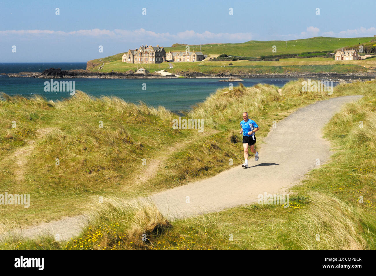 Joggen in Sanddünen am Runkerry Trail, Portballintrae in der Nähe von Bushmills und Portrush, County Antrim, Nordirland. Sommer Stockfoto