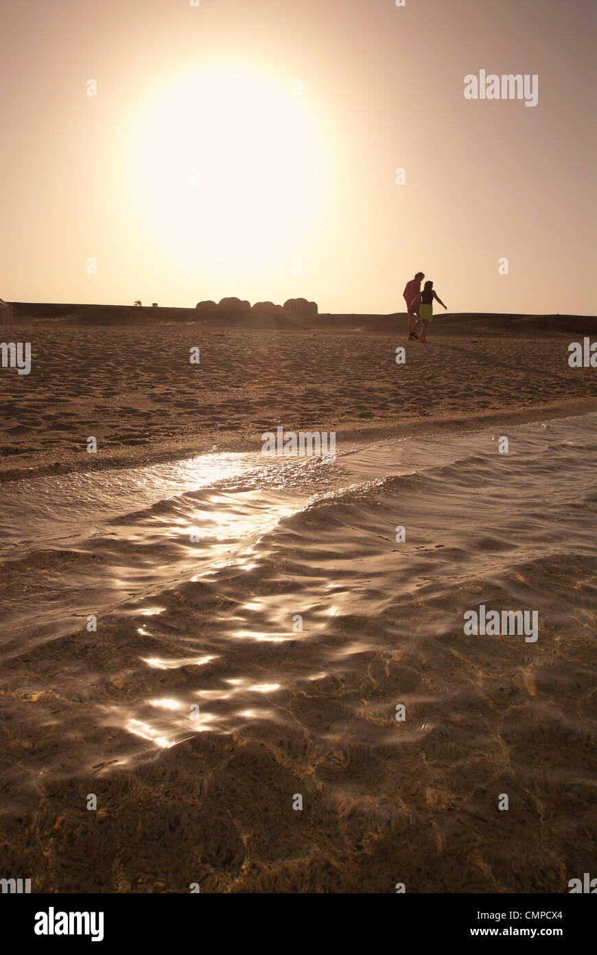Paare, die am Strand bei Sonnenuntergang Marsa Alam Rotes Meer Ägypten Stockfoto
