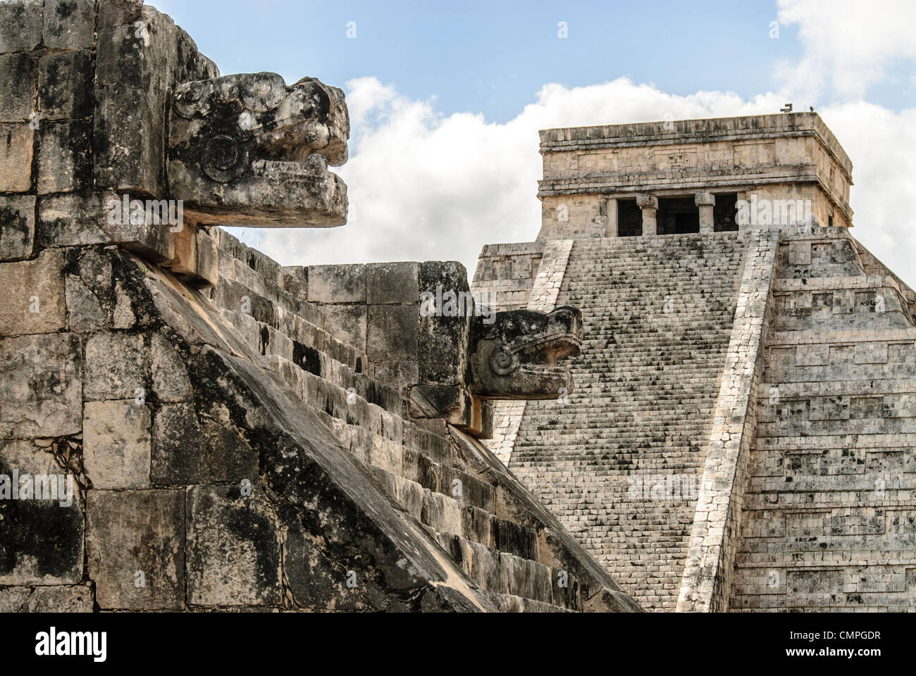 CHICHEN ITZA, Mexiko — im Hintergrund rechts befindet sich der Tempel des Kukulkan (El Castillo) und links im Vordergrund zwei geschnitzte jaguar Köpfe der Venus-Plattform in der archäologischen Zone Chichen Itza, Ruinen einer großen Maya-Zivilisationsstadt im Herzen der mexikanischen Halbinsel Yucatan. Stockfoto