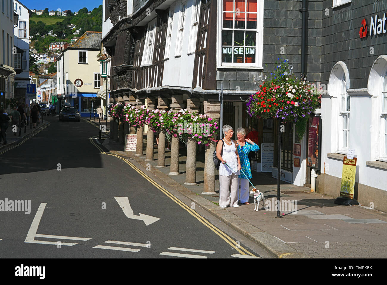 Der historische Butterwalk Arcade mit seinen bunten Blumenampeln in Dartmouth, Devon, England, UK Stockfoto