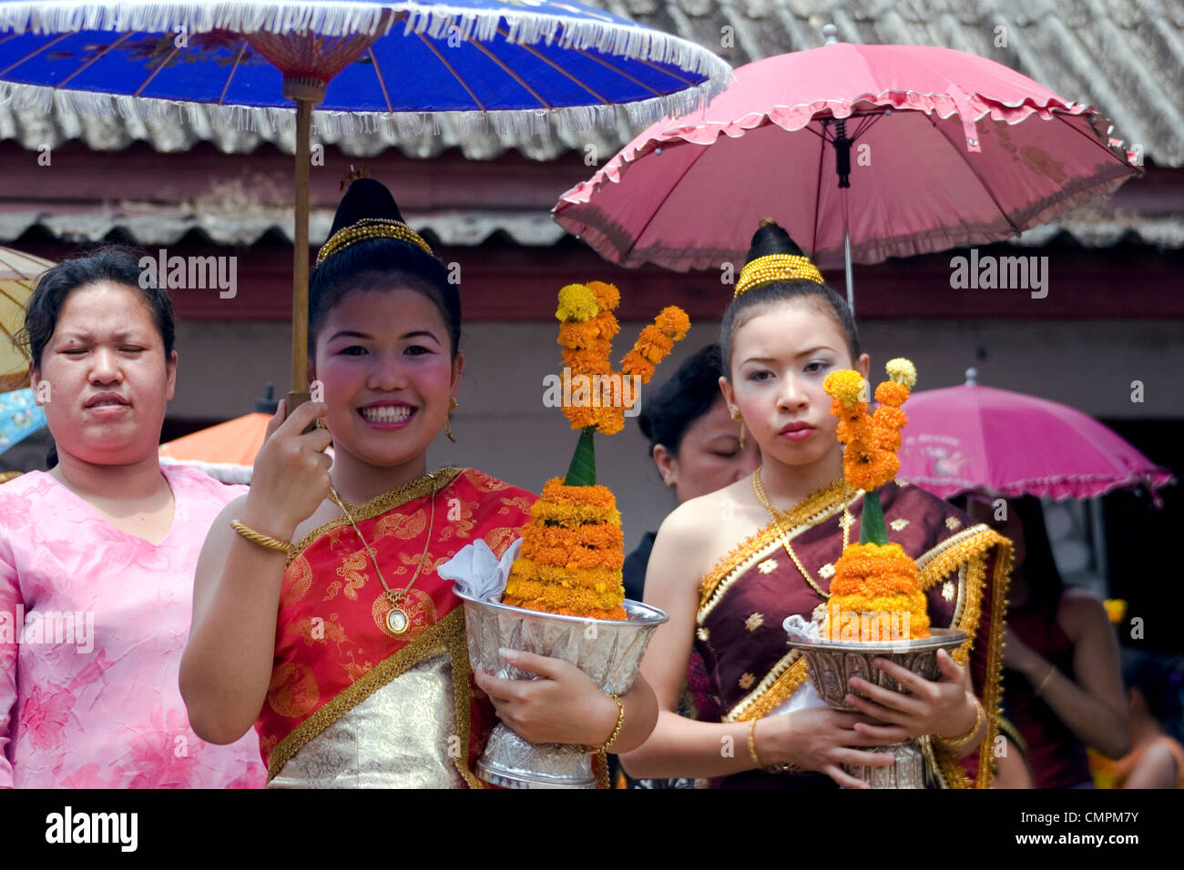 Zwei junge asiatische Frauen tragen Silberschalen mit Blumen Leis vor dem Lao Neujahr Festival in Luang Prabang, Laos. Stockfoto