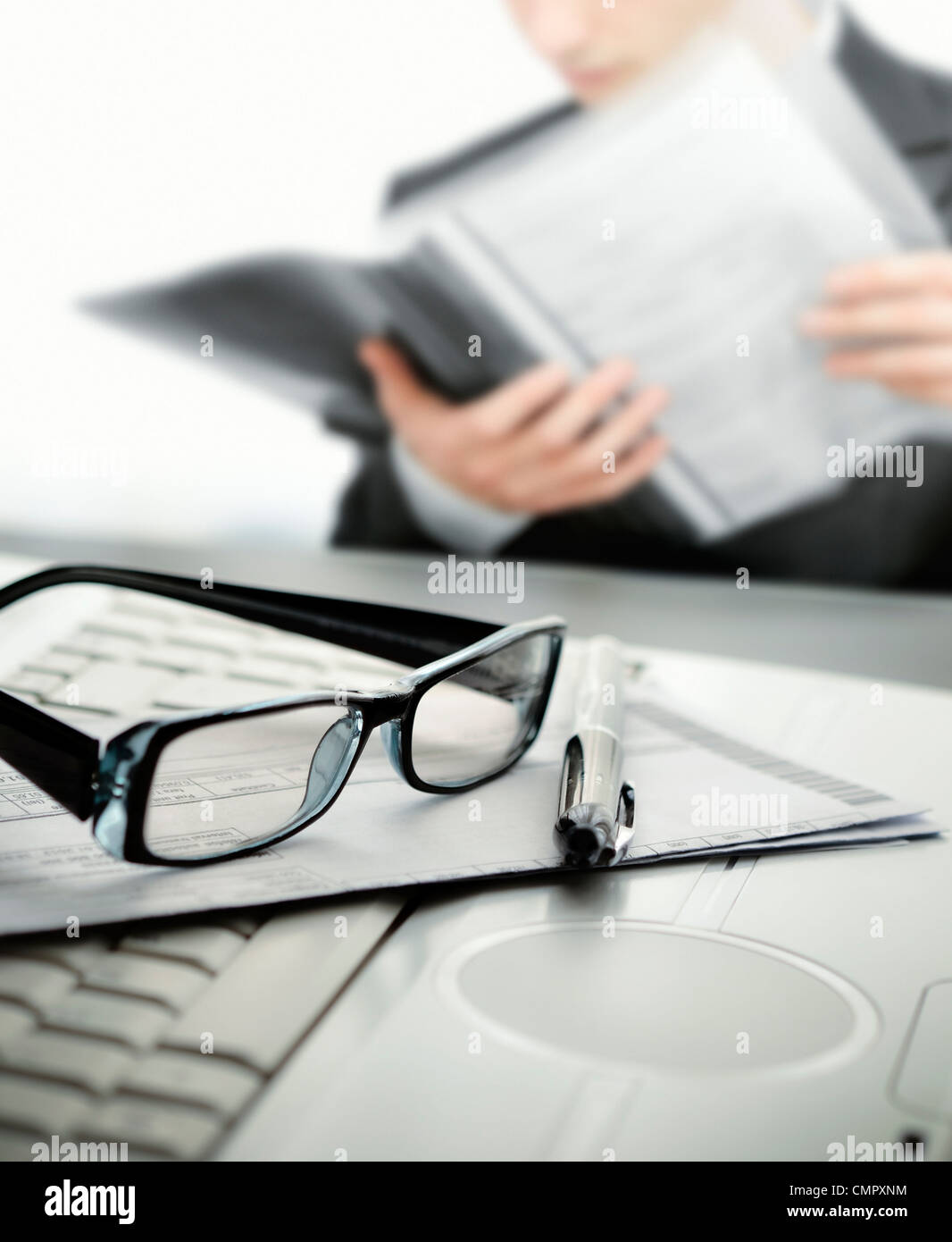 Unternehmer, die einen Vertrag mit selektiven Fokus auf Gläsern und Stift lesen Stockfoto