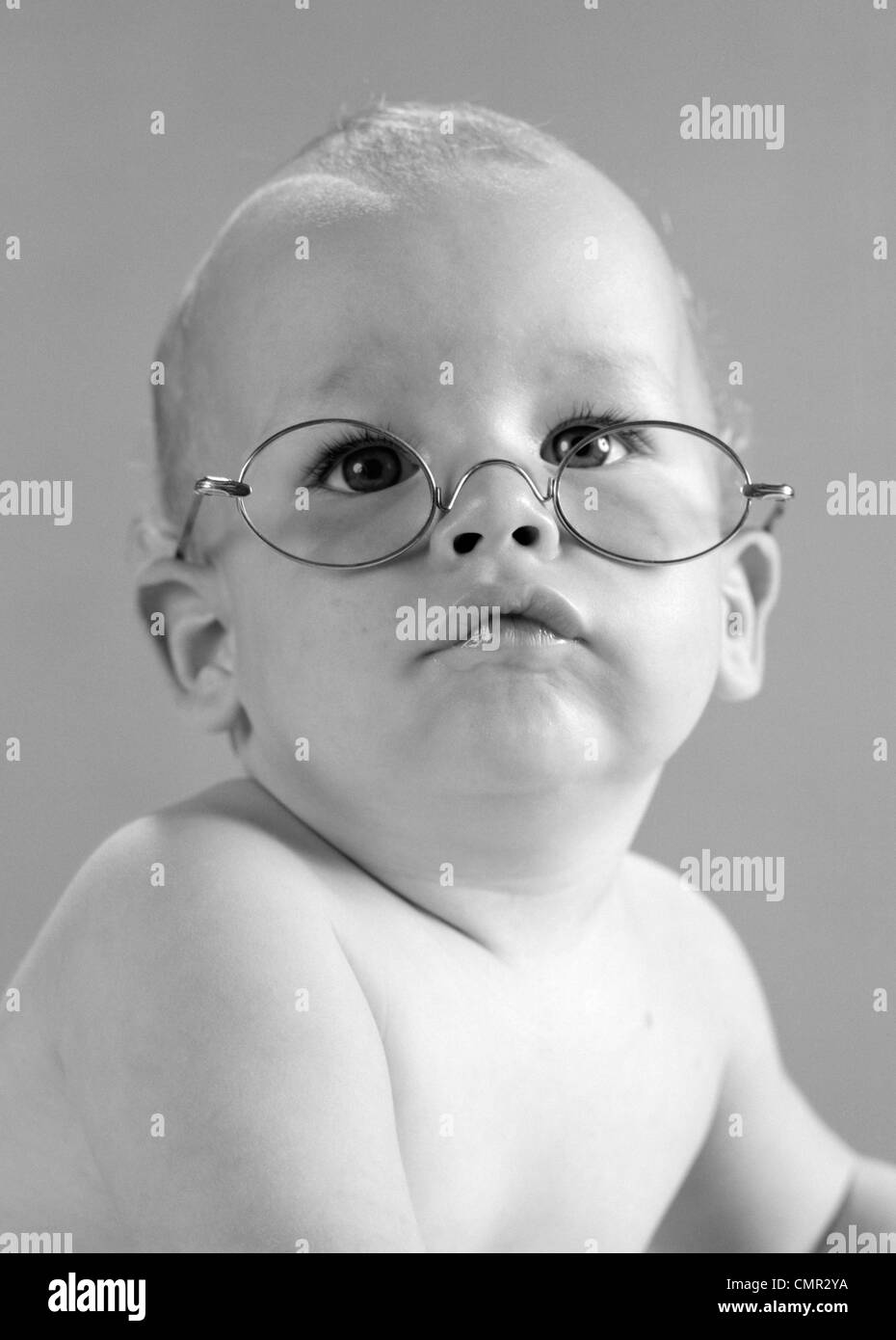 1960ER JAHRE BABY WEARING DRAHT-UMRANDETEN OMA BRILLEN Stockfoto