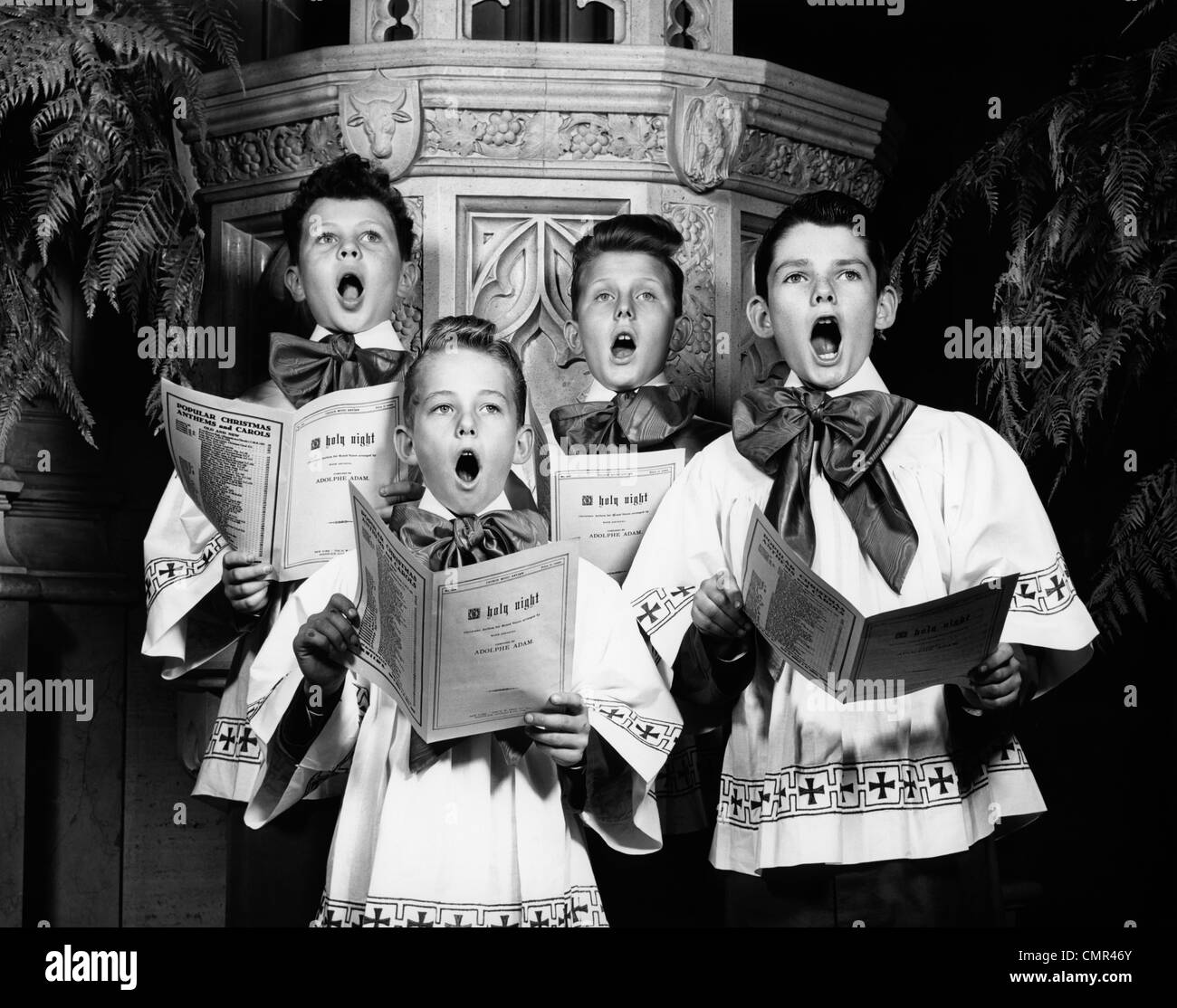 1940ER JAHRE PORTRÄT VON 4 CHORKNABEN SINGEN O HOLY NIGHT Stockfoto