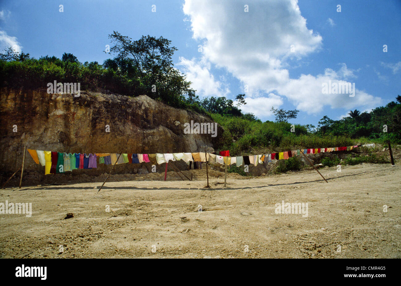 Eine lange Reihe von Multi-farbige Wäsche hängt auf einer Linie trocknen in der Sonne auf einem Sandstrand, Poneloya, Nicaragua Stockfoto