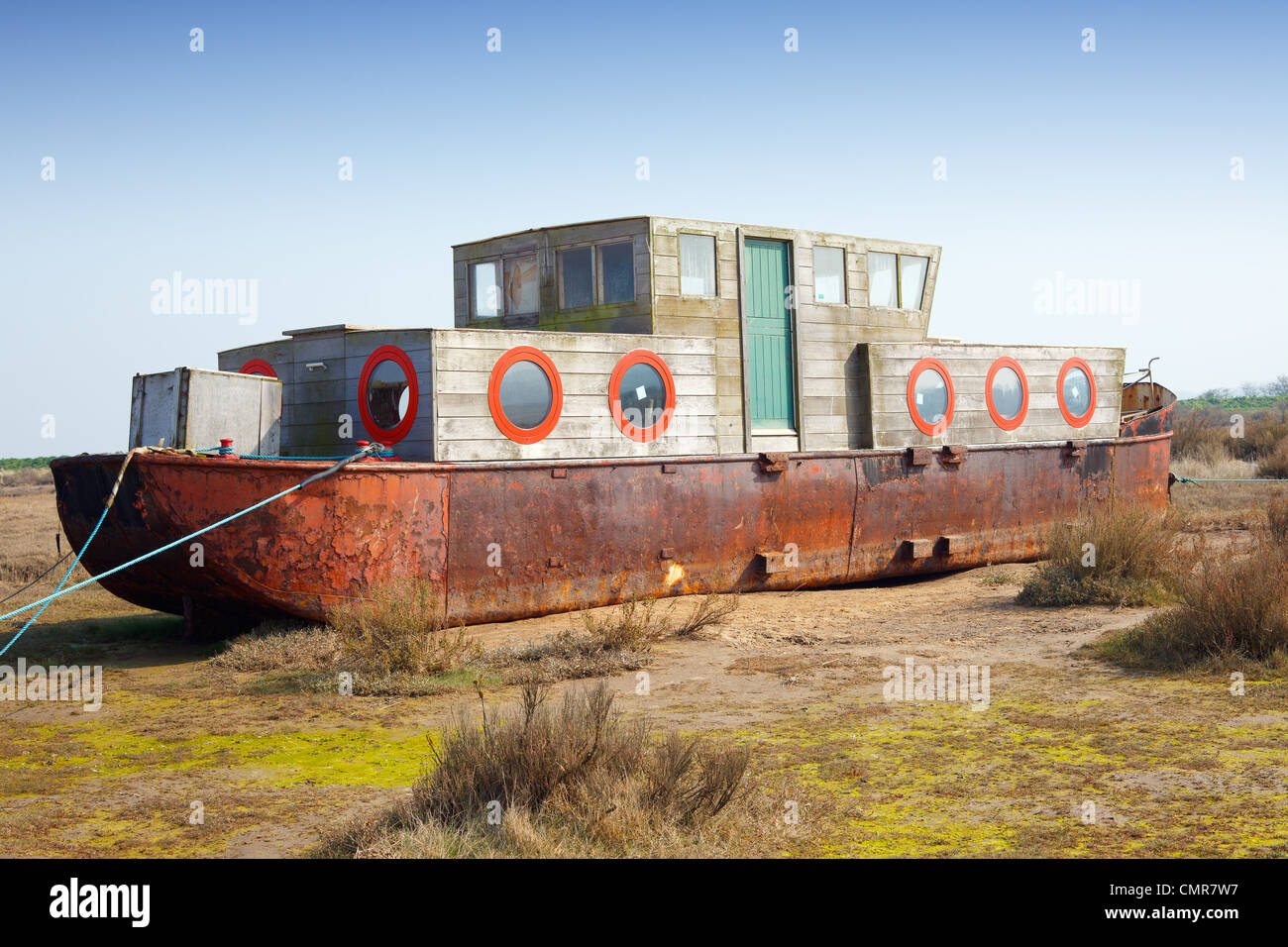 Einem umgebauten Lastkahn gemacht in einem Hausboot sitzen hoch und trocken auf einem Salzwiesen 'East Anglia' UK Stockfoto