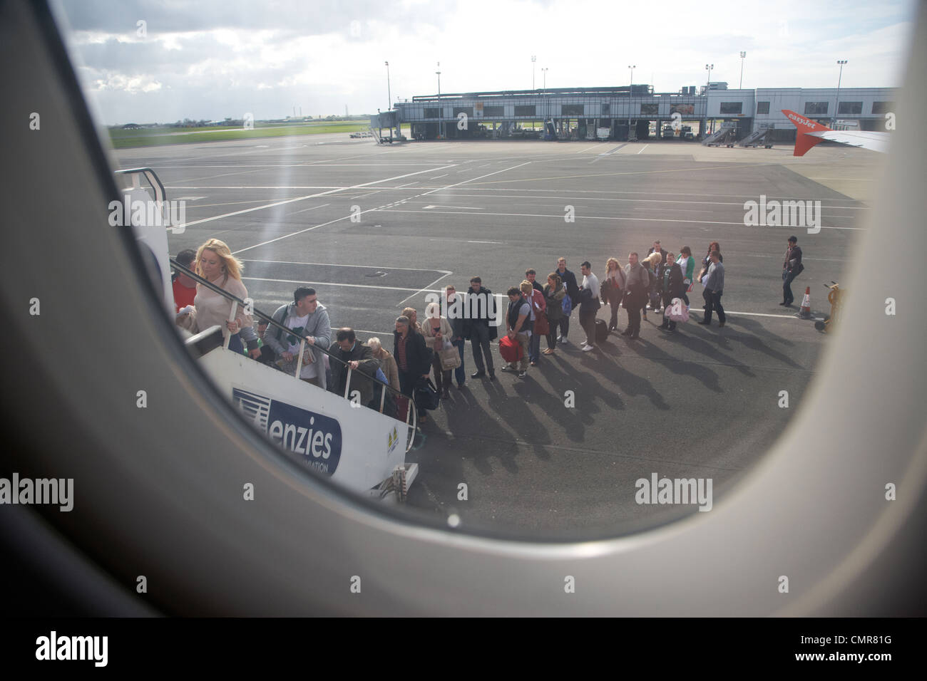 mit Blick auf die lange Schlange von Fluggästen Easyjet-Flugzeuge am Flughafen Belfast Nordirland Vereinigtes Königreich. Stockfoto