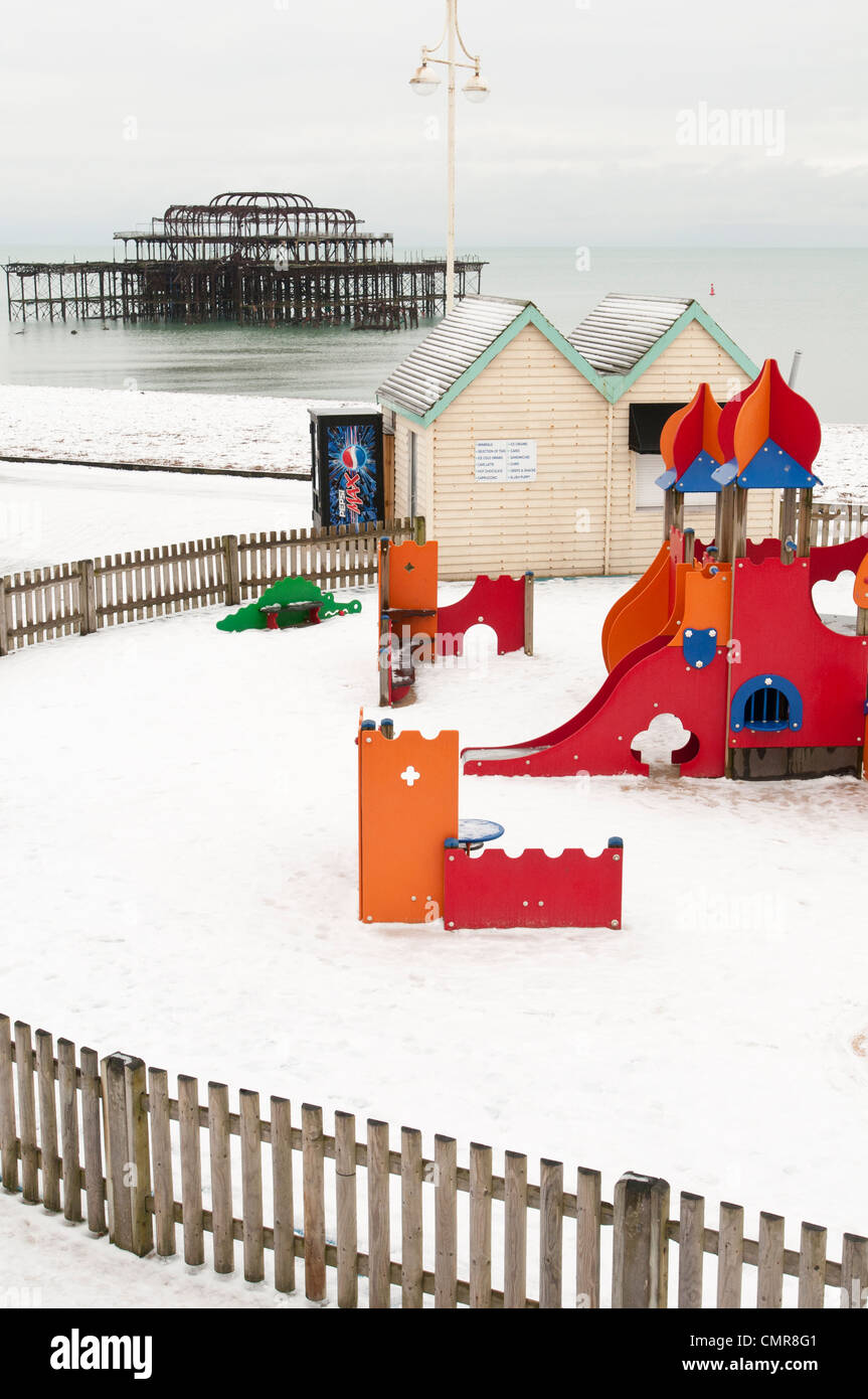 Die Schale der Brighton Pier West betrachtet über eine verlassene Kinder, Schnee bedeckten Spielplatz Stockfoto