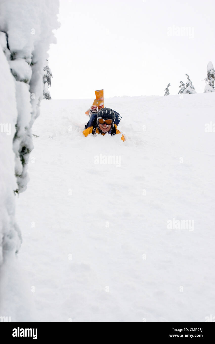 Mann lachend in den Schnee nach einem Sturz beim Skifahren, Lago Peak in den Cascade Mountains nahe dem Coquihalla Highway, BC Stockfoto