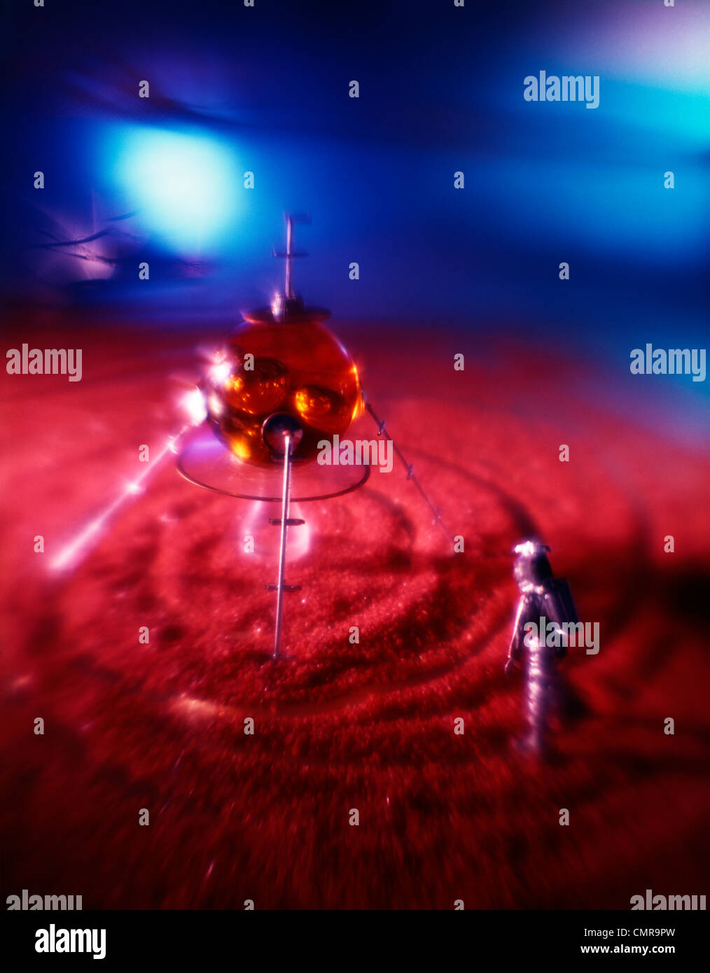 1970ER JAHREN SILBER MANN ASTRONAUT AUßERIRDISCHER RAUMSCHIFFE IM ROTEN SAND ZU Stockfoto