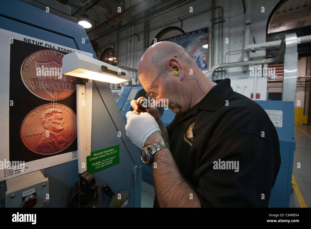 Denver, Colorado - eine Arbeitskraft inspiziert fertigen Penny-Münzen bei der United States Mint. Stockfoto