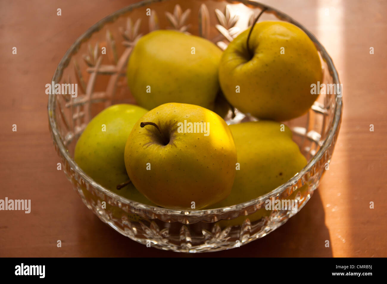 goldene Äpfel in Kristall Obst Schale Stillleben. Stockfoto