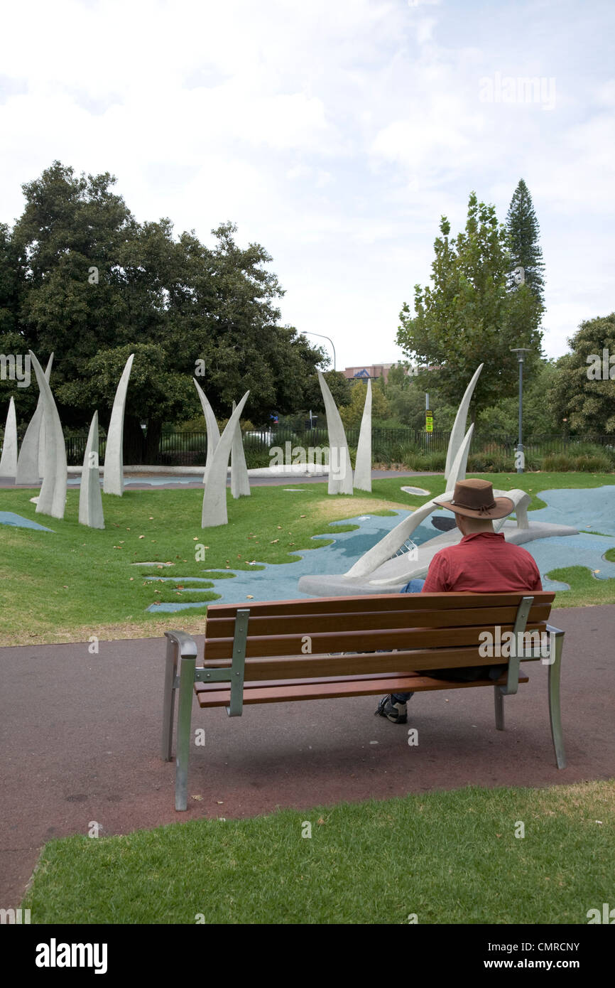 Mann, sitzend auf Bank Blick auf Skulpturen in Adelaide Stockfoto