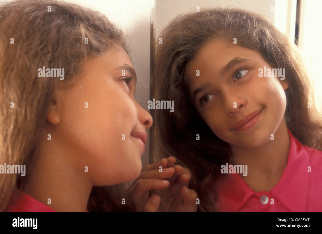 hübsche Mädchen, die sich selbst im Spiegel betrachten Stockfoto