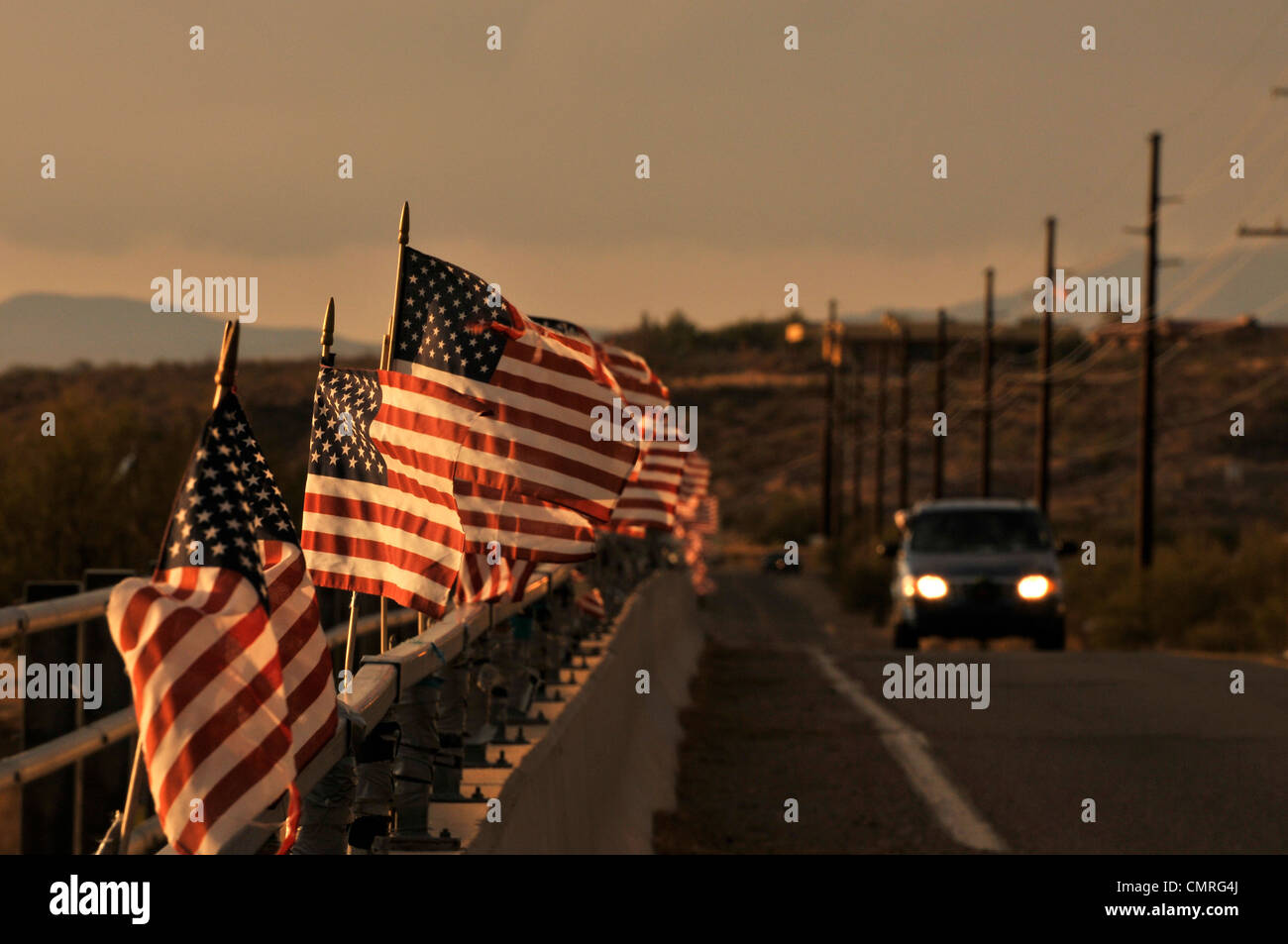 Amerikanische Flaggen angebracht zu einer Brücke über den Río Santa Cruz Schlag im Wind in Green Valley, Arizona, USA. Stockfoto