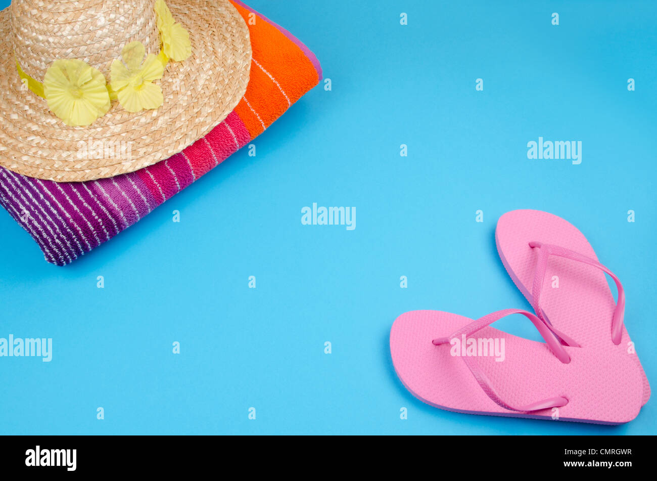 Rosa Flip-flops auf blauem Hintergrund mit einem Sonne-Hut und Strand-Handtuch Stockfoto