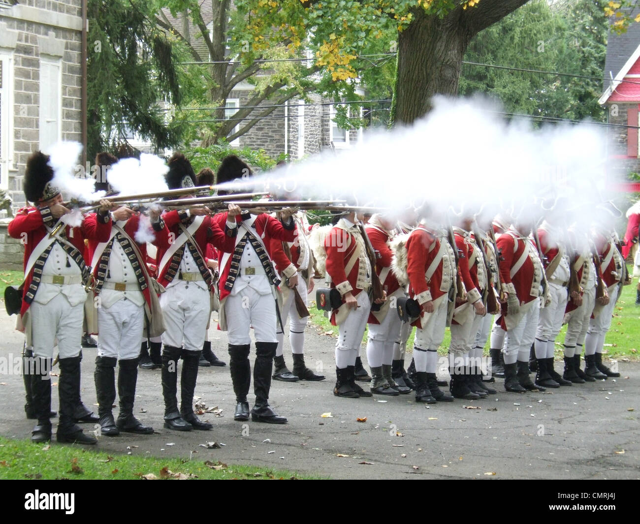 1777 KAUEN 4. OKTOBER BRITISCHE SOLDATEN FEUERN MUSKETE VOLLEY REENACTMENT HAUS SCHLACHT VON GERMANTOWN PHILADELPHIA PENNSYLVANIA USA Stockfoto