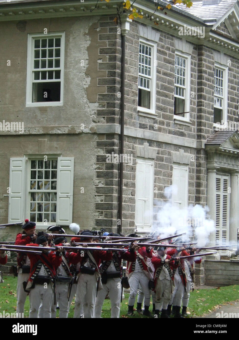 1777 KAUEN 4. OKTOBER BRITISCHE SOLDATEN FEUERN MUSKETE VOLLEY REENACTMENT HAUS SCHLACHT VON GERMANTOWN PHILADELPHIA PENNSYLVANIA USA Stockfoto