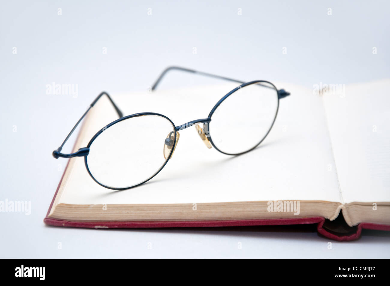 Buch und Brille als Symbol für das Konzept der Gewohnheit zu lesen oder zu studieren Stockfoto