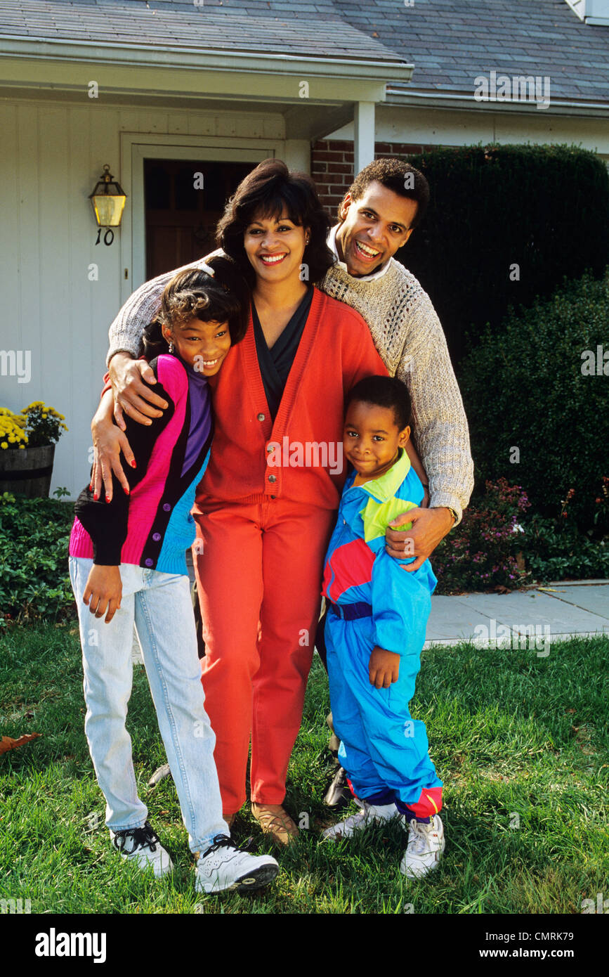 1992 1990S RETRO-AFROAMERIKANISCHE FAMILIE RASEN VOR DEM HAUS Stockfoto