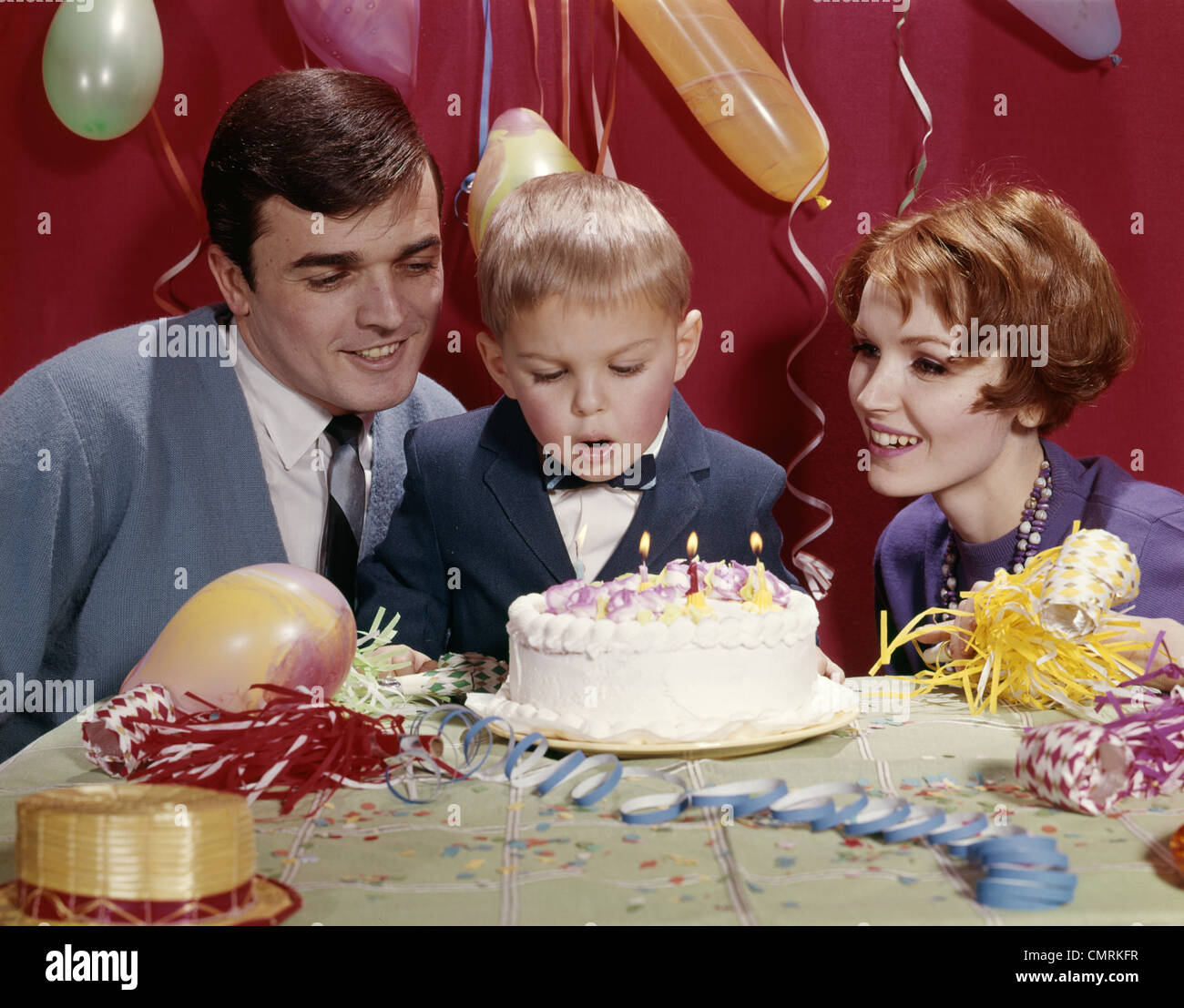 FAMILIE VATER UND MUTTER MIT SOHN UND GEBURTSTAG KUCHEN MIT KERZEN STUDIO FEIER Stockfoto