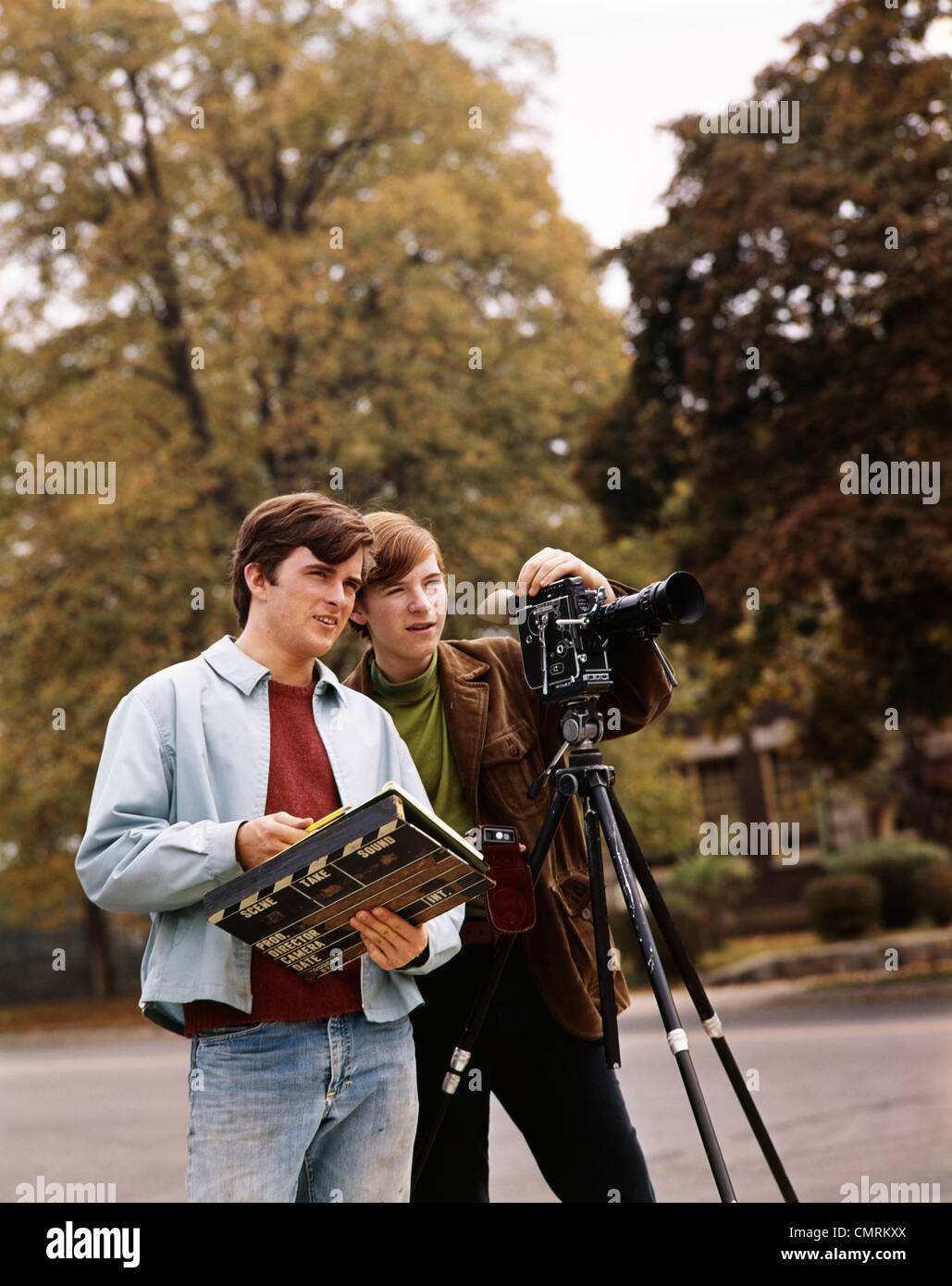 1960ER JAHRE ZWEI TEEN BOYS EINE OPERATIVE FILMKAMERA DER ANDEREN HOLDING SZENEMARKE IM FREIEN Stockfoto